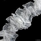 Close-up of white chiffon frilly trim showcasing its delicate design.