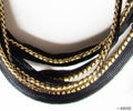 Black sew in pipe trim with gold edge on a white background