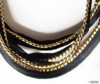 Black sew in pipe trim with gold edge on a white background