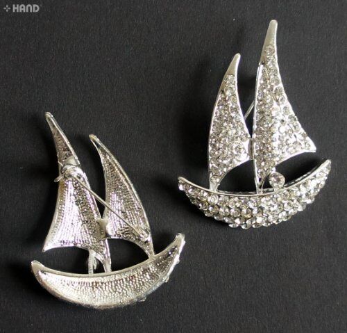 Close-up of a clear crystal boat brooch with silver detailing.