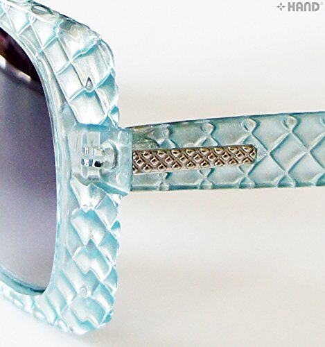 Sunglasses worn by a model outdoors, highlighting their retro style.