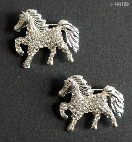 Two elegant clear crystal horse brooches displayed on a white background.