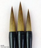Brushes resting on a calligraphy paper with ink splatters.