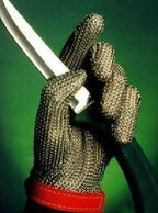 Glove being worn while using a rotary cutter in a fashion studio.