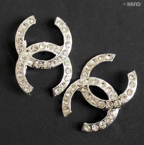 Two elegant clear crystal brooches displayed on a white background.