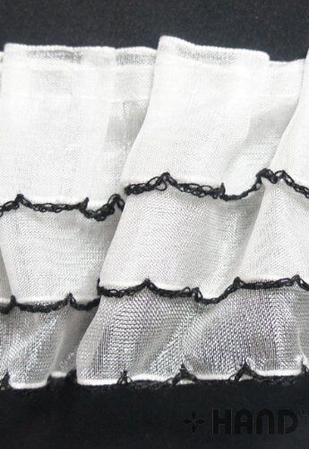 Full view of the three layer frill trim on a flat surface.