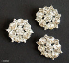 Small silver brooch with clear crystals, elegant design.