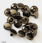 Flat dark copper press studs displayed on a white background