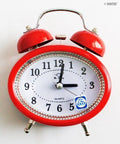 Oval-shaped twin bell alarm clock in a vibrant colour