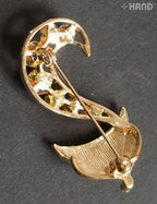 Close-up of a clear crystal fox brooch with gold detailing.