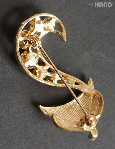 Close-up of a clear crystal fox brooch with gold detailing.