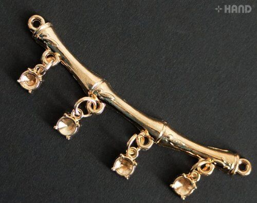 Close-up of A34 metal embellishments in gold tone.