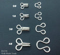 Silver hook and eye fasteners, size 4, in a pack of approximately 250 sets.
