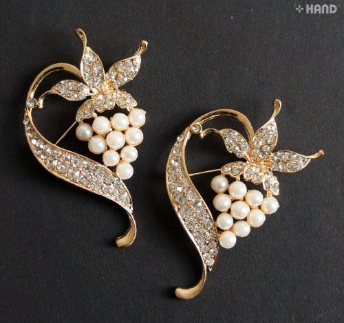 Two elegant crystal pearl gold brooches displayed on a white background.