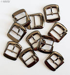 Pack of gunmetal tone shoe boots bag belt buckles arranged neatly.