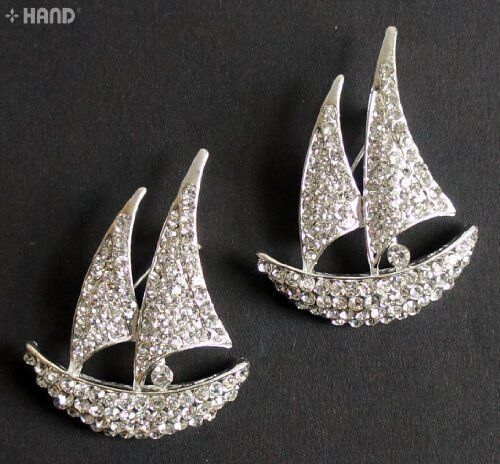 Clear crystal boat brooch on a fabric background showcasing its shine.