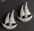 Two elegant clear crystal boat silver brooches displayed together.