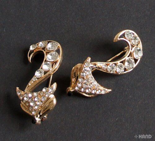 Two elegant clear crystal fox gold brooches displayed together.