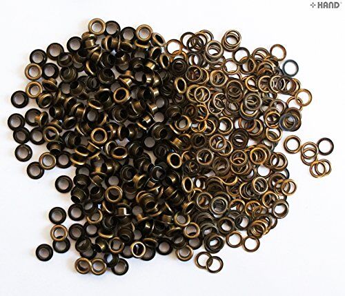 Assorted vintage gold eyelets displayed on a crafting surface.