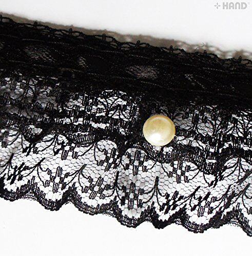 Close-up of the black lace ruffle showing pearl detailing.