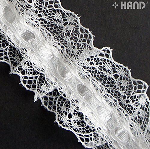 Roll of 10 metre white nylon ribbon lace trim on a table.