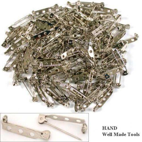 Safety lock brooch pins displayed on a fabric background.