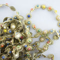 Gold tone garment trim with coloured enamel design.