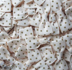 Close-up of cream ribbon bow showcasing brown dot design.