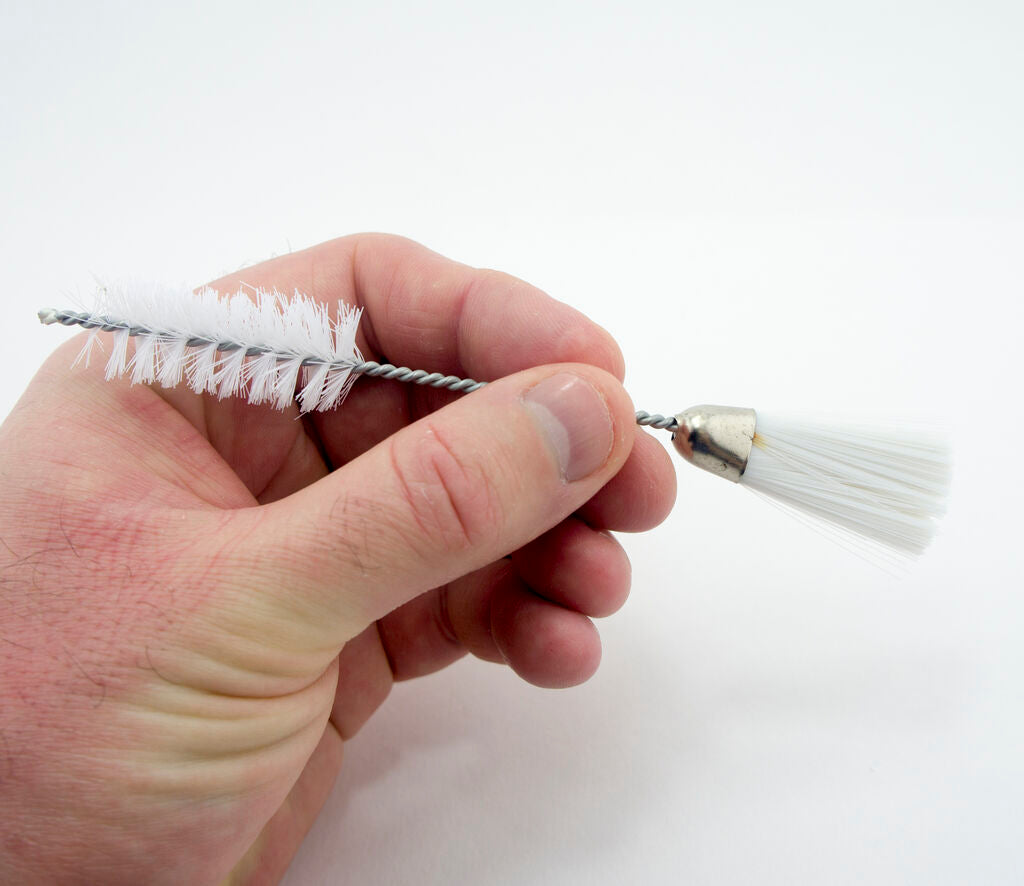 Close-up of the double ended brush designed for sewing machines.