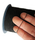 Large roll of black shirring elastic on a white background
