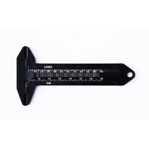 Black button measurer placed on a fabric background