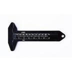 Black button measurer placed on a fabric background