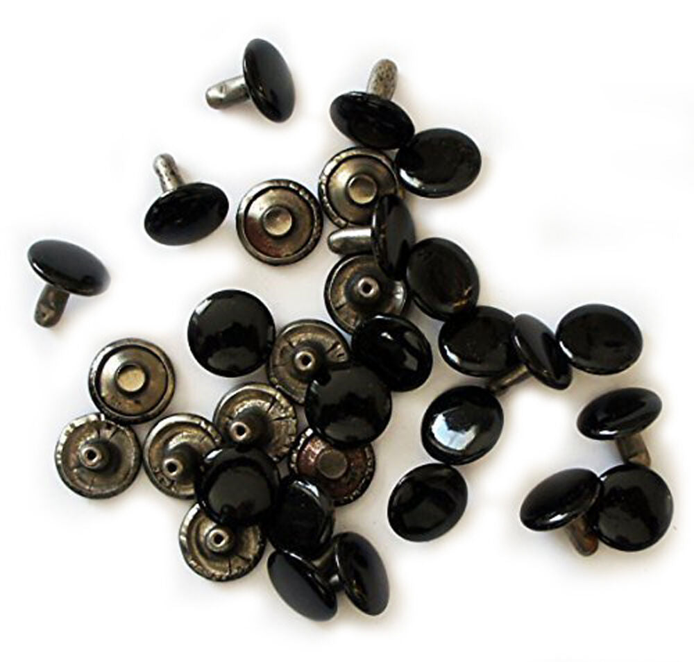 Flat black press studs displayed on a white background
