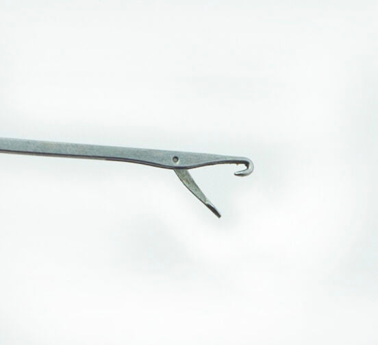 Close-up of a plastic loop turner showing its thin design.
