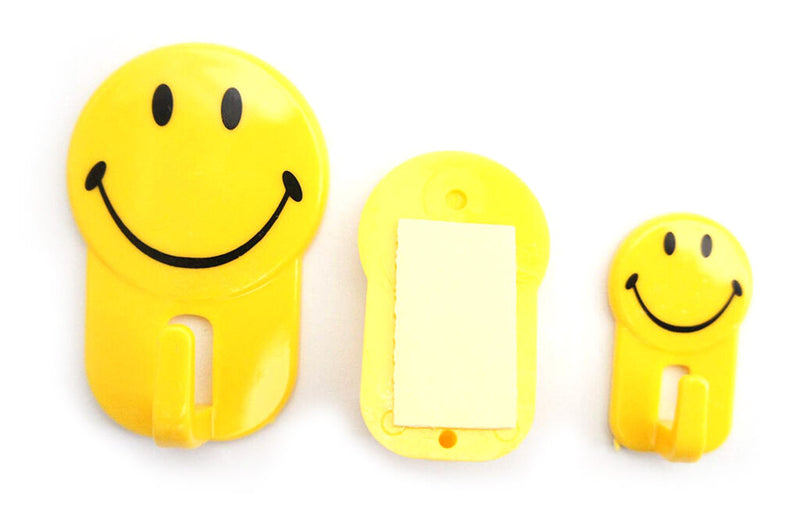 Three self adhesive hooks with smiley face design on a white background.