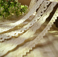 White cotton lace trim, 15mm wide on a spool.