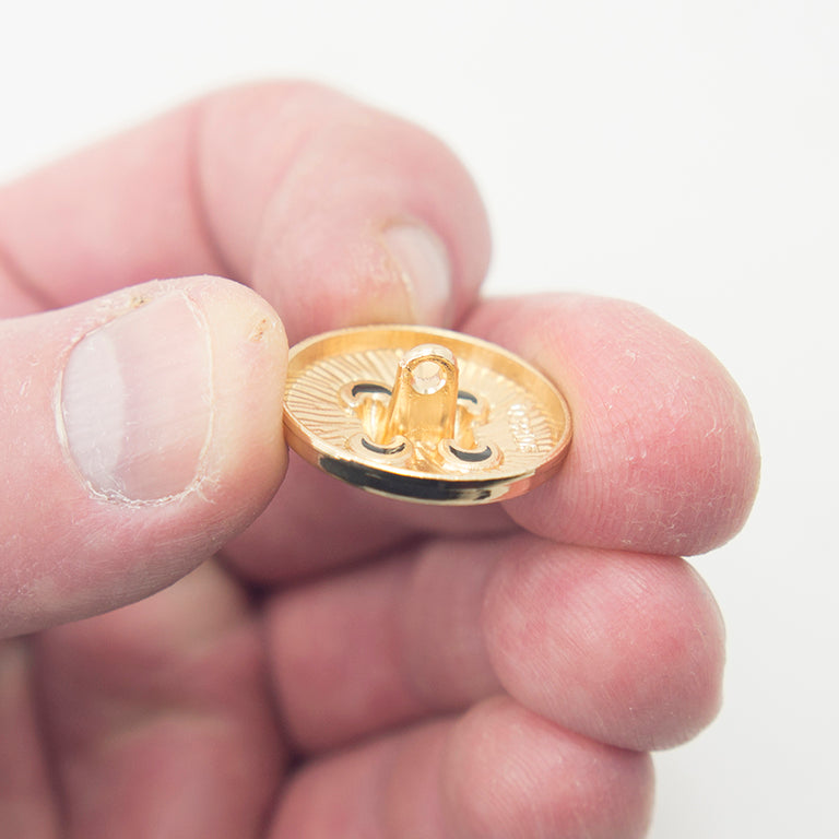 Close-up of a gold tone button showing its 15 mm diameter.