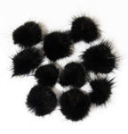 Close-up of black mink pom pom trim showcasing its soft texture.