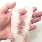 Close-up of baby pink mink sew in pipe trim on a fabric surface.