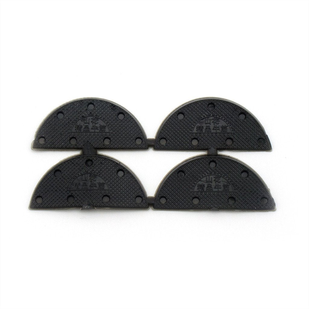 Black rubber shoe pads arranged neatly, highlighting their shape.
