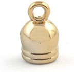 Close-up of a small gold bell trim showing its colour and shape