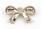 Gold colour bow shaped embellishments on a fabric background.