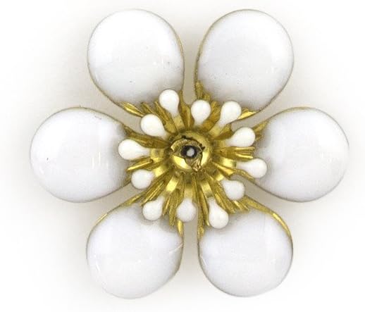 Close-up of a white enamel and brass flower sew-on trim.