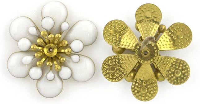 Close-up of a white enamel and brass flower embellishment.