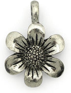 Silver flower pendant displayed with sewing accessories.