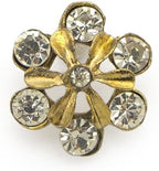 Gold diamante crystal flower brooch pin worn on a jacket lapel.