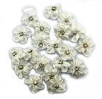Display of white satin ribbon and diamante flower trims on a table