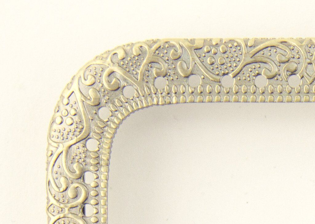 Squared metal purse frame showcasing perforations and design