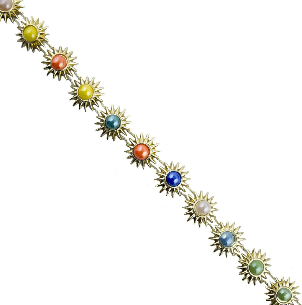 Close-up of gold tone trim showing colourful crystals and enamel detail.