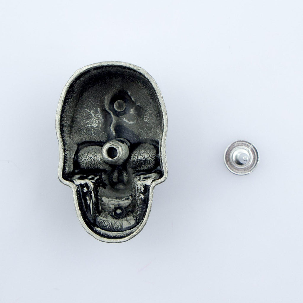 Skull studs displayed on a fabric background